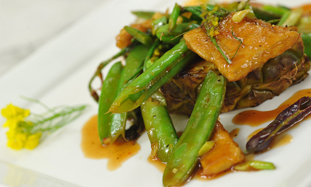 A plated dish of snap peas and pineapple from Baker Creek Restaurant