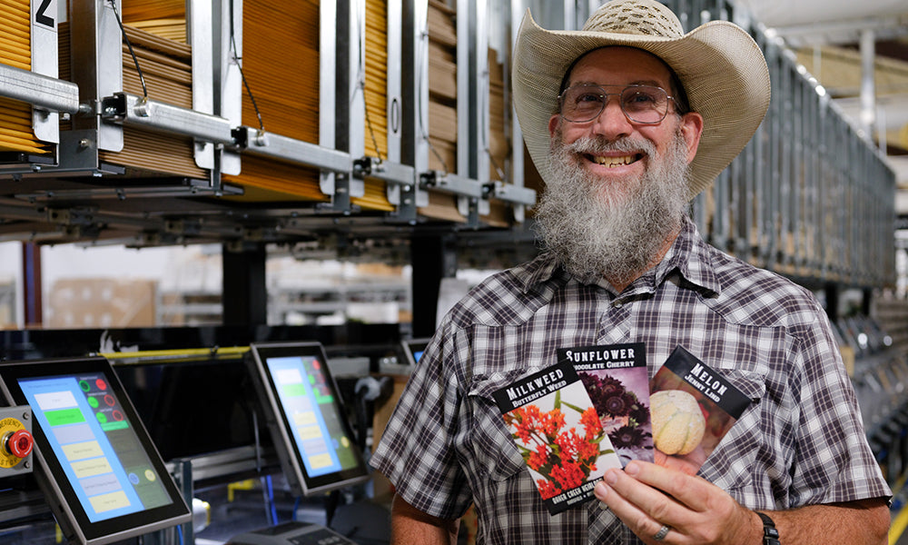 Team member holding seed packets in our Seymour packing facility
