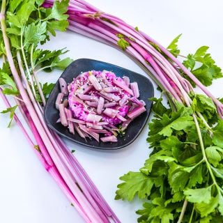 Cooked and raw Chinese Pink Celery with pink rice on a white background.