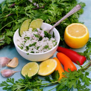 Dwarf Lemon Cilantro and rice surrounded by lemons, peppers, heirloom garlic and cilantro leaves.