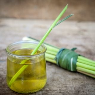 Lemongrass stick in lemongrass tea with bundle on wooden table.