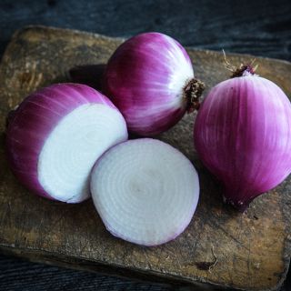 Round Tropea Onions on cutting board.