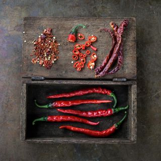 Cayenne Long Thin Peppers, whole, sliced and dried in wooden box.