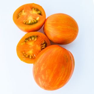 Whole and cut Apricot Zebra Tomatoes on white background.