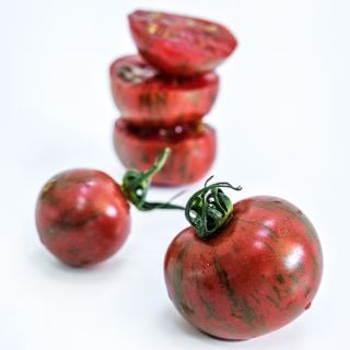 Purple Bumble Bee Tomatoes arranged on a high key background.