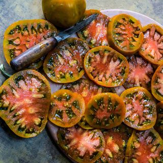 Sliced Thorburn's Terra-Cotta Tomatoes on a terra-cotta plate.