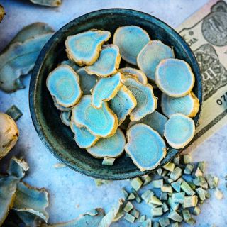 Sliced Blue Turmeric that turns a deeper blue when it is oxidized in a blue bowl.