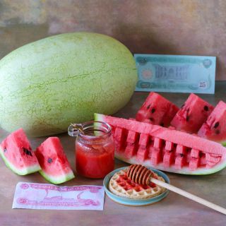 Whole and cut Ali Baba Watermelon with watermelon jam on amulti-colored baground.