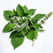Lime Basil Leaves in small crystal bowl with flowers arranged on a white background.