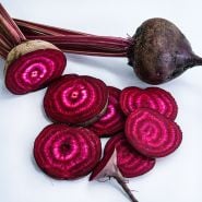 Sliced and whole Betina Beets on a white background.