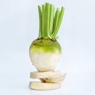 A single Albino Beet balanced on slices against a white background.