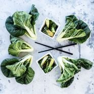 Cooked and fresh Baby Milk Bok Choy on a grey background.