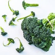 Waltham 29 Broccoli heads tied with hemp twine surrounded by florets of broccoli on a white background.