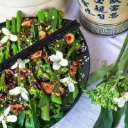 Broccoli Yod Fah recipe on a black plate with chopsticks.