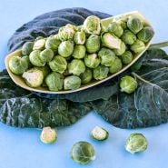 A platter of Long Island Improved Brussels Sprouts on a bed of leaves.