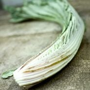 Gobbo Di Nizzia Cardoon stems on a weathered wood background.
