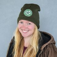 A smiling woman enjoying her Baker Creek Logo Beanie.