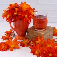 Cosmic Red Coreopsis flowers with tea on a light background.