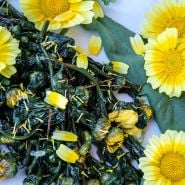 Big Leaf Tong Ho Chrysanthemum sauteed leaves with petal on white plate.