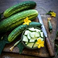 Early Fortune Cucumbers on wooden board with quartered slices.