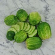 Richmond Green Apple Cucumbers, sliced on marble countertop.