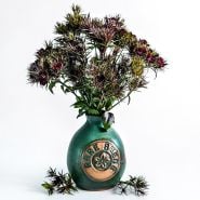 An arrangement of Black Adder Dianthus in a Handmade Stoneware Pottery Vase with a rareseeds logo on it on white.