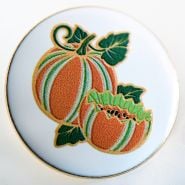 A close-up view of a Baker Creek Kajari Melon Limited Edition Pin on a light background.