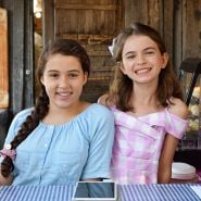 Smiling girls at their tea booth at the Baker Creek Fall Harvest Festival.
