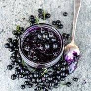 Chichiquelite Huckleberry jam with berries and spoon on a stone background.