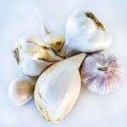 Garlic cloves and bulbs included in the Garlic Lover Sampler Pack arranged on a white background.