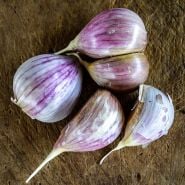 A close-up view of Leningrad Garlic cloves on a wooden background.