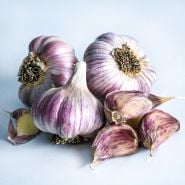 A cluster of Vietnamese Red Garlic bulbs arranged on light background.