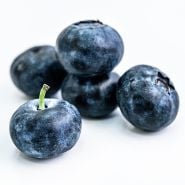 A close-up of Chandler Blueberries on a white background.