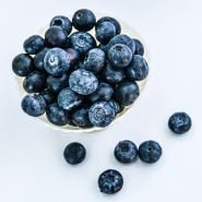 A bowl of large Chandler Blueberries in a bowl on a white background.