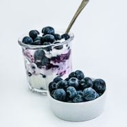 Top Hat Blueberries with yogurt in a dish with a bowl of blueberries on the side.