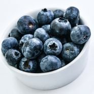A close-up side view of Top Hat Blueberries in white bowl.