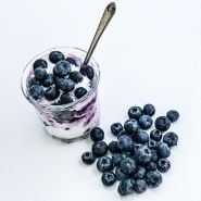 Overhead view of Top Hat Blueberries with yogurt in a dish surrounded by loose berries.