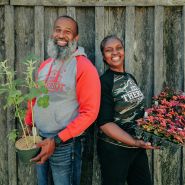 A couple of speakers pose with plants at the Baker Creek Spring Planting Festival.