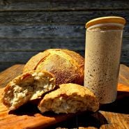Ms. Debbie’s Rye Starter With loafs of bread on a wood table.