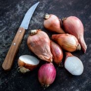 Cut and whole Red Catawissa Walking Onion Bulbs with a knife.