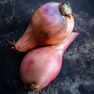 A pair of Red Catawissa Walking Onion Bulbs on dark brown background.
