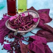 Red Orach salad with leaves and oil and vinegar on a light blue background.
