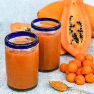 Sweet David Papaya smoothies with fruit and papaya balls on a light background.