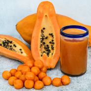 Cut and whole Sweet David Papaya with a papaya smoothie on a light background.