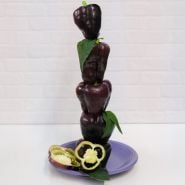 Five deep purple Zulu Sweet Peppers stacked one on top of another on a purple plate.