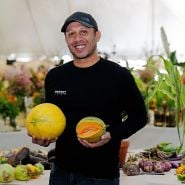 A speaker holdig some melons at the Baker Creek Fall Harvest Festival.