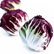 A trio of whole Chioggia 506 Radicchio heads on a white background.