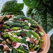 A salad made of Bloomsdale Long Standing Spinach surrounded by leaves on a light background.