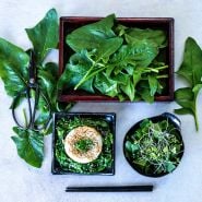 Jiromaru Spinach leaves in a box , sauteed over rice and as a salad arranged on light background.