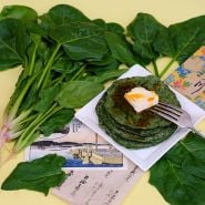 Jiromaru Spinach with spinach pancakes and fresh leaves on yellow background.